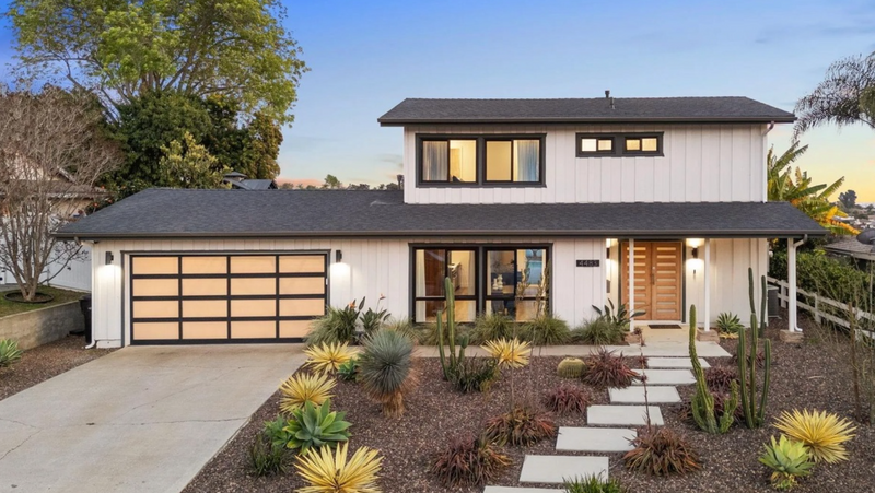 Modern house with a driveway and garden in a suburban setting